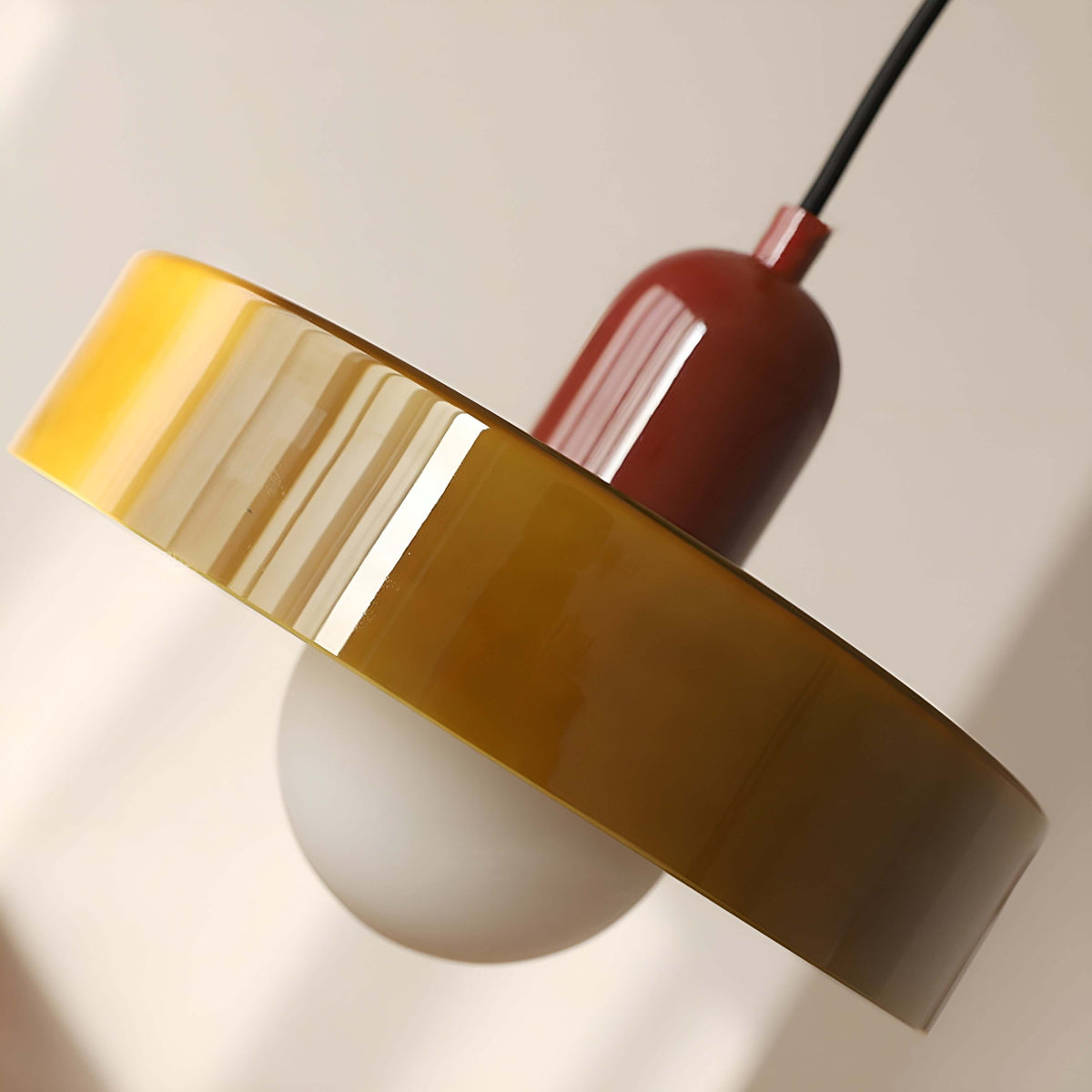 Nowoczesna szklana lampa wisząca w kolorze żółtym i czerwonym z minimalistycznym designem.