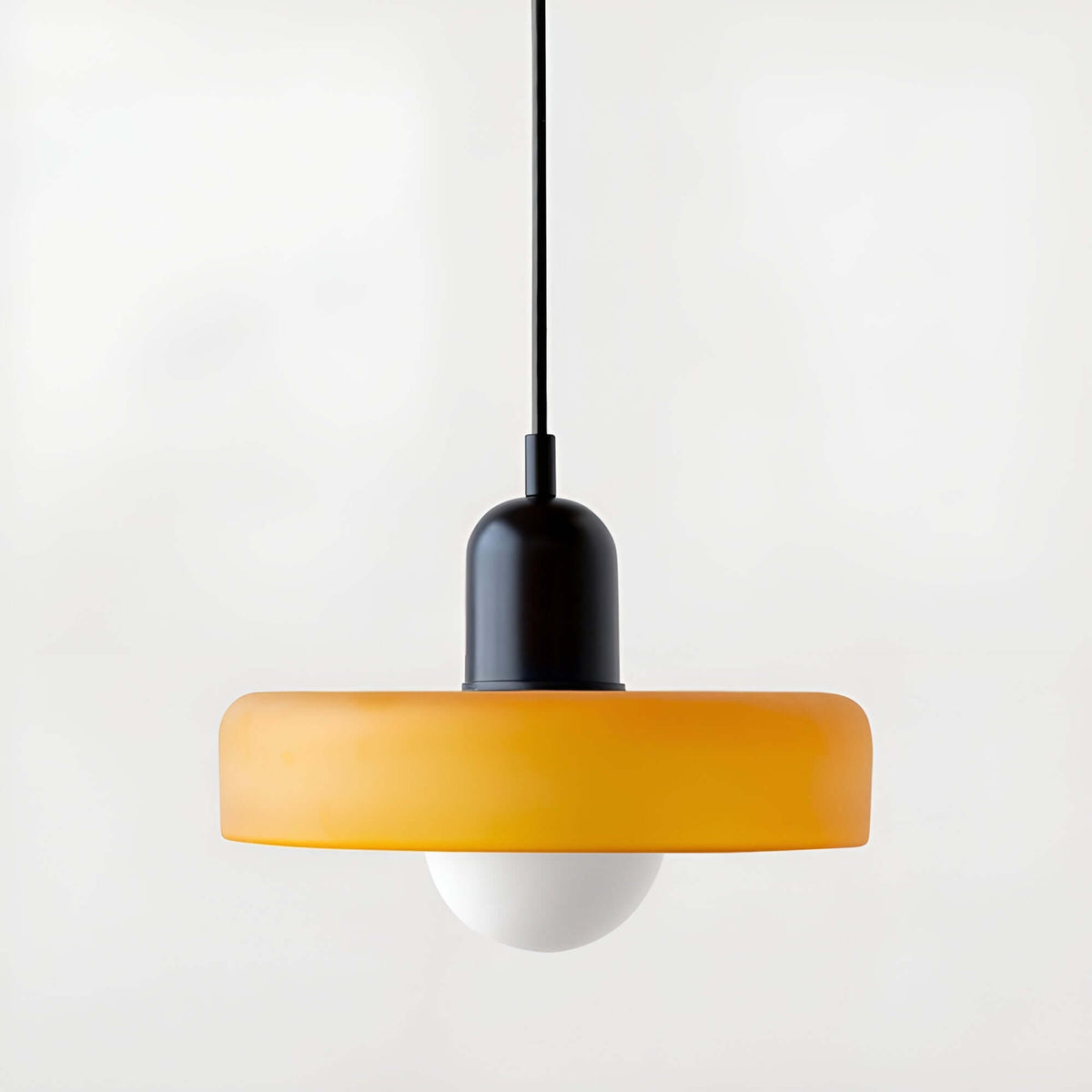 Nowoczesna szklana lampa wisząca w kolorze żółtym z białą kulką, idealna do minimalistycznych wnętrz.